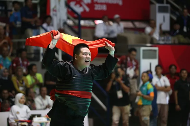 Võ sĩ Pencak Silat Nguyễn Văn Trí giúp cờ Việt Nam tung bay tại đấu trường Á vận hội. ẢNH: PHẠM HUY