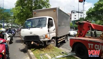 Xe tải mất lái ủi văng dải phân cách lao sang đường, húc đổ cây xanh