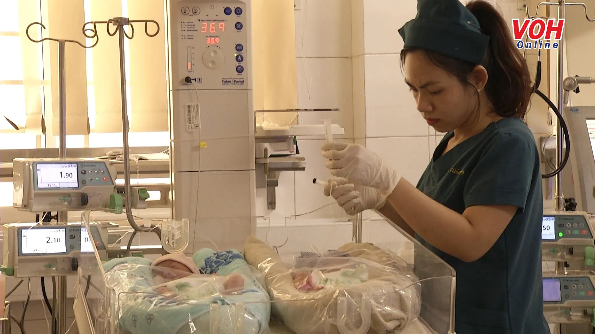 Nhân viên y tế đang truyền sữa cho trẻ sơ sinh