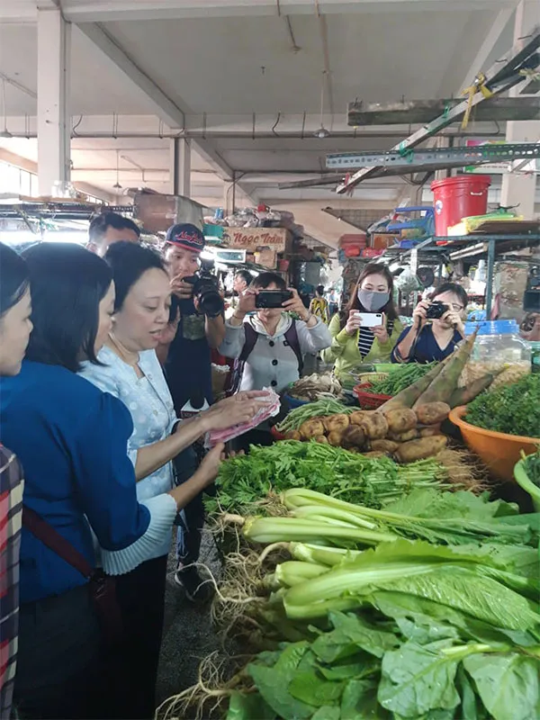 Bà Lan kiểm tra hóa đơn chứng hàng mua về bán tại tại sạp rau chợ Phú Lâm