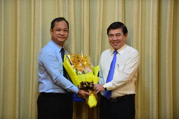 Chủ tịch UBND TP.HCM Nguyễn Thành Phong trao quyết định bổ nhiệm cho ông Nguyễn Bình Minh - Ảnh: TTO