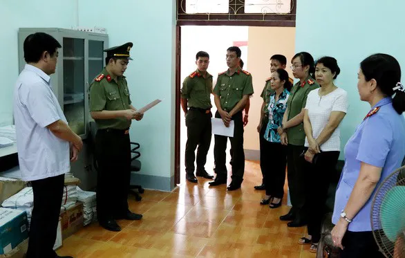 Công bố quyết định khởi tố đối với bà Nguyễn Thanh Nhàn (thứ hai từ phải sang) - Phó trưởng phòng khảo thí và quản lý chất lượng, Sở GD-ĐT tỉnh Sơn La