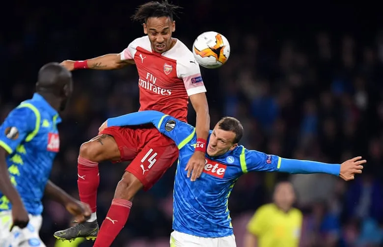 Tiền đạo Aubameyang của Arsenal trong pha không chiến với cầu thủ Napoli.