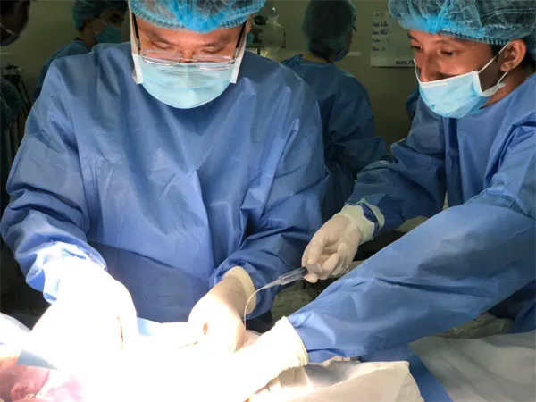 Bác sĩ đang đặt máy tạo nhịp tim tạm thời cho bé sơ sinh nhịp tim chậm