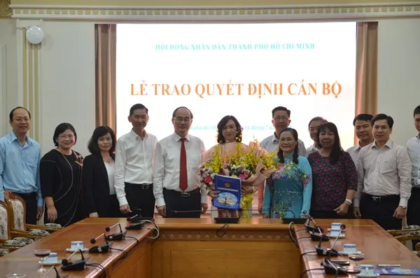 Bà Phan Thị Thắng Phó Chủ tịch Hội đồng nhân dân TP nhận quyết định và hoa chúc mừng tại buổi lễ trao nghị quyết.