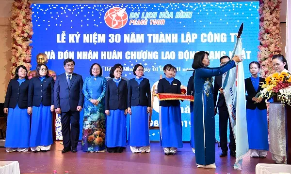 Tập thể lãnh đạo và nhân viên công ty du lịch Hòa Bình đón nhận Huân chương lao động hạng nhất từ Phó chủ tịch nước Đặng Thị Ngọc Thịnh.