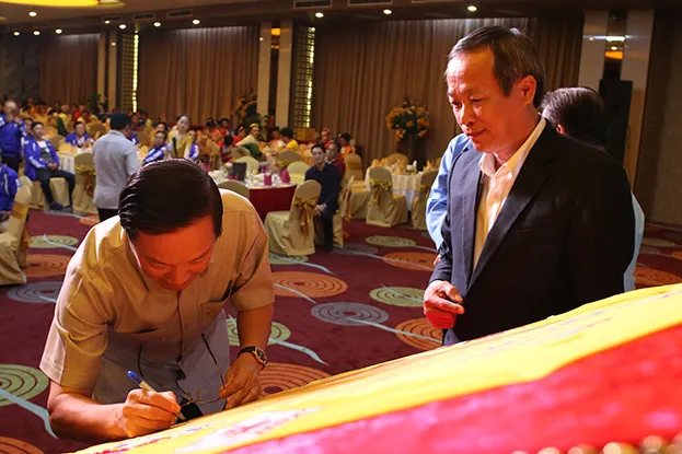 Ông Nguyễn Bá Hùng, Thứ trưởng Bộ Ngoại giao, Đại sứ đặc mệnh toàn quyền Việt Nam tại Lào ký tên lưu niệm lên chiếc áo đặc biệt của giải