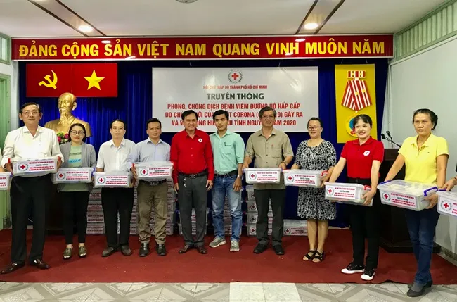 Ông Trần Trường Sơn - Chủ tịch Hội chữ thập đỏ thành phố trao tặng khẩu trang, dung dịch rửa tay đến các đơn vị quận hội. 