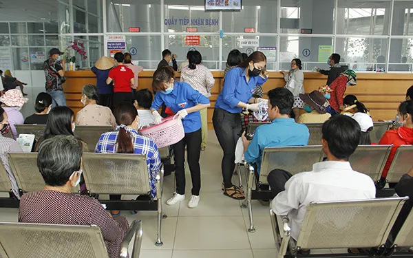 Đoàn viên Chi đoàn Đài Truyền thanh huyện Bình Chánh phát khẩu trang cho người dân đến khám bệnh tại Bệnh viện huyện Bình Chánh