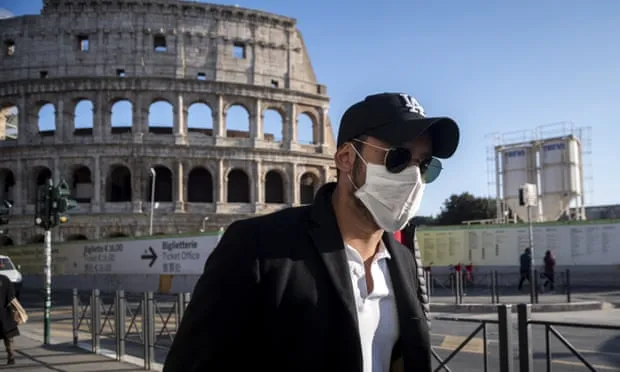 Khách du lịch với khẩu trang đi thăm Colosseum ở Rome, Italia.