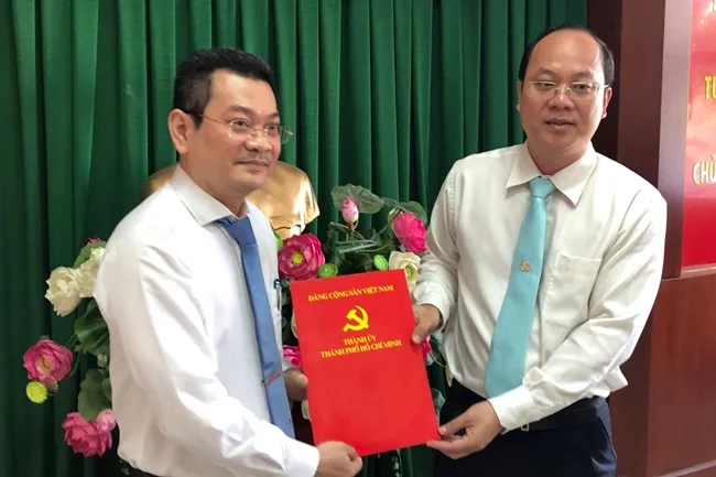 Ông Nguyễn Hồ Hải, Trưởng Ban Tổ chức Thành ủy trao quyết định của Ban Thường vụ Thành ủy chỉ định ông Hoàng Minh Tuấn Anh giữ chức Phó Bí thư Quận ủy quận 7.