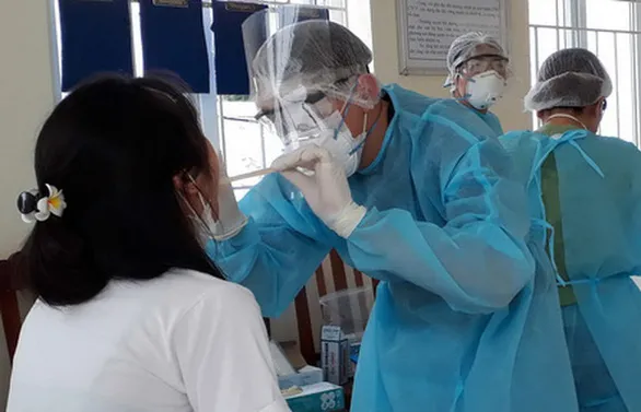 Bác sĩ lấy mẫu xét nghiệm COVID-19 cho các cư dân tại một khu cách ly tập trung ở Hà Nội 