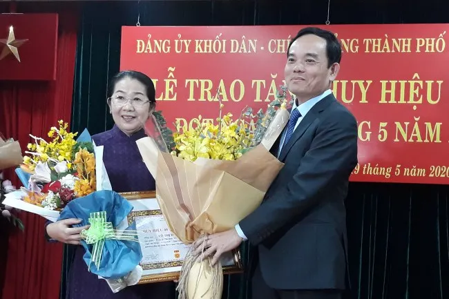 Phó Bí thư Thành ủy Trần Lưu Quang tặng hoa chúc mừng đảng viên Võ Thị Dung-Phó Bí thư Thành ủy nhận huy hiệu 40 năm tuổi đảng.