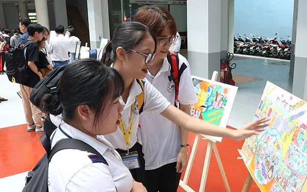Sinh viên tham quan triển lãm tranh Hành động vì thiên nhiên - cuộc thi đã được Trường tổ chức 