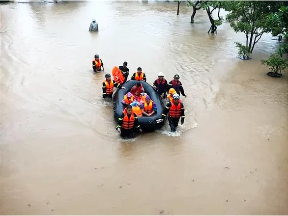 Công an dùng xuồng đưa học sinh ra ngoài tại một trường học ở TP Đông Hà ngày 16/10 do nước ngập. Ảnh: TTO 