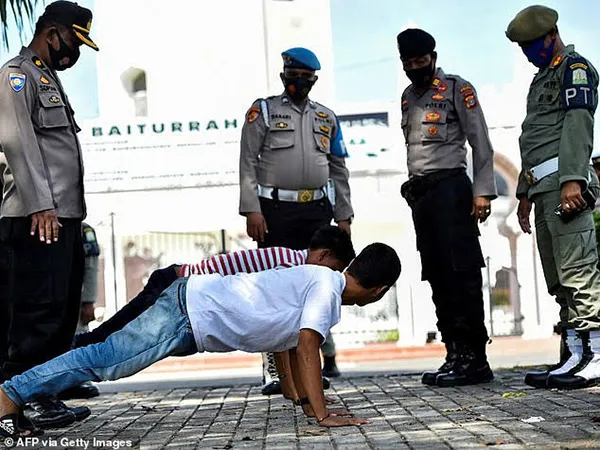 Hai thanh niên bị hít đất vì không đeo khẩu trang nơi công cộng tại Indonesia