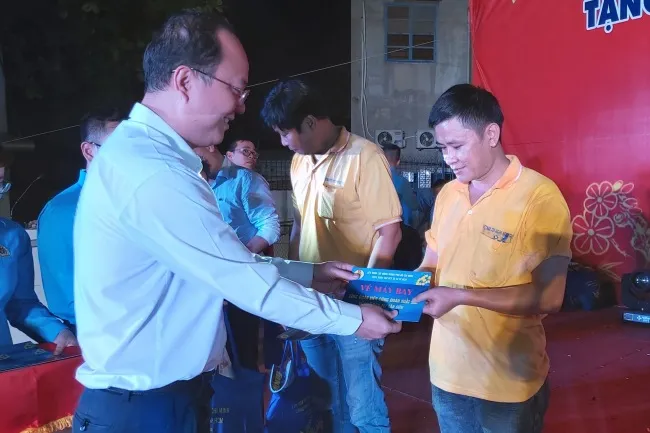 Phó bí thư Thành ủy TPHCM Nguyễn Hồ Hải trao vé máy bay cho công nhân.