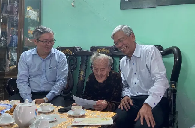 Lãnh đạo Thành phố và lãnh đạo huyện Nhà Bè nghe mẹ Việt Nam anh hùng Lê Thị Hồ, 102 tuổi, đọc các dòng chữ chúc Tết Tân Sửu 2021.