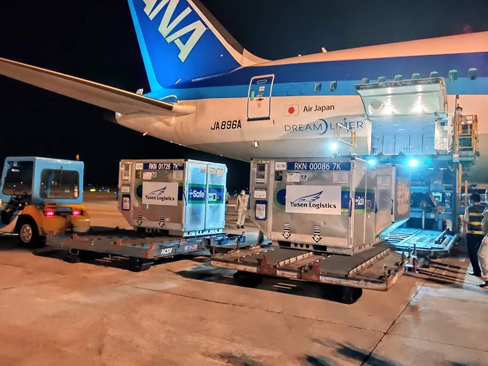 Những container bảo quản vắc xin từ Nhật Bản sang Việt Nam đang được đưa từ máy bay xuống để vận chuyển đến kho bảo quản   