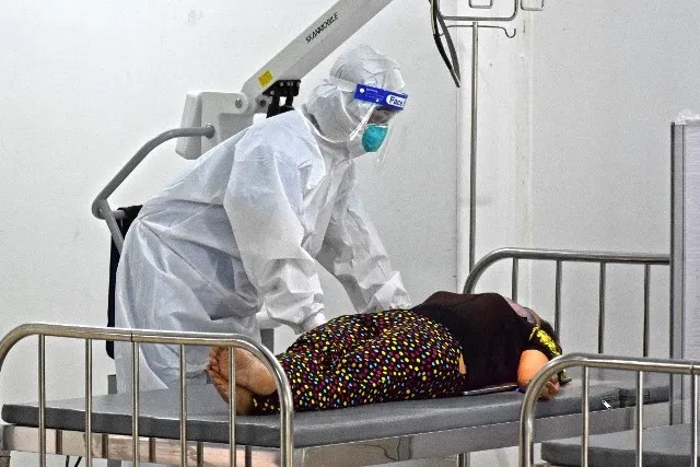 Nhân viên y tế hướng dẫn bệnh nhân tư thế nằm để chụp X-Quang tại Bệnh viện Dã chiến thu dung điều trị số 5. Ảnh: HCDC. 