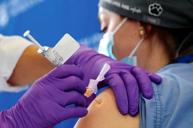 Nhân viên y tế đang tiêm vắc-xin ngừa Covid-19 cho một người dân Mỹ. (Ảnh: Reuters)