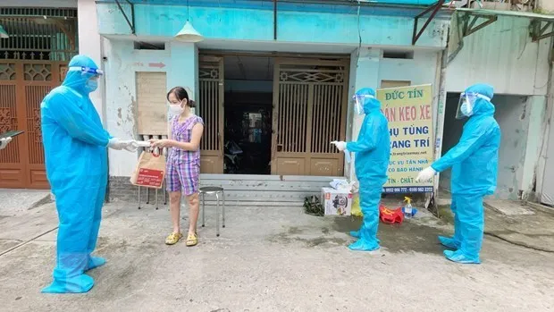 Nhân viên y tế trạm y tế lưu động phường 25, quận Bình Thạnh phát túi thuốc cho F0 điều trị tại nhà.