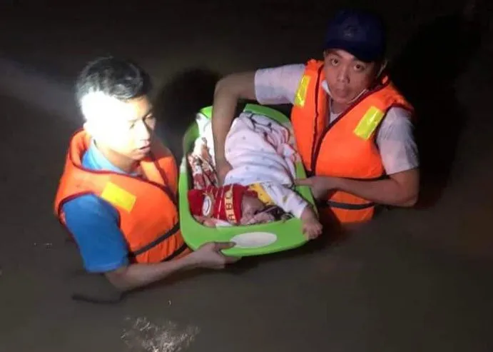 Lực lượng cứu hộ đưa em bé sơ sinh chưa đầy 1 tháng tuổi vượt dòng lũ dữ trong đêm đến nơi an toàn. 