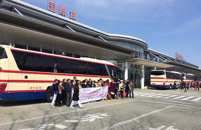 Du khách tour charter chụp hình lưu niệm trước sảnh Sân bay Fukushima