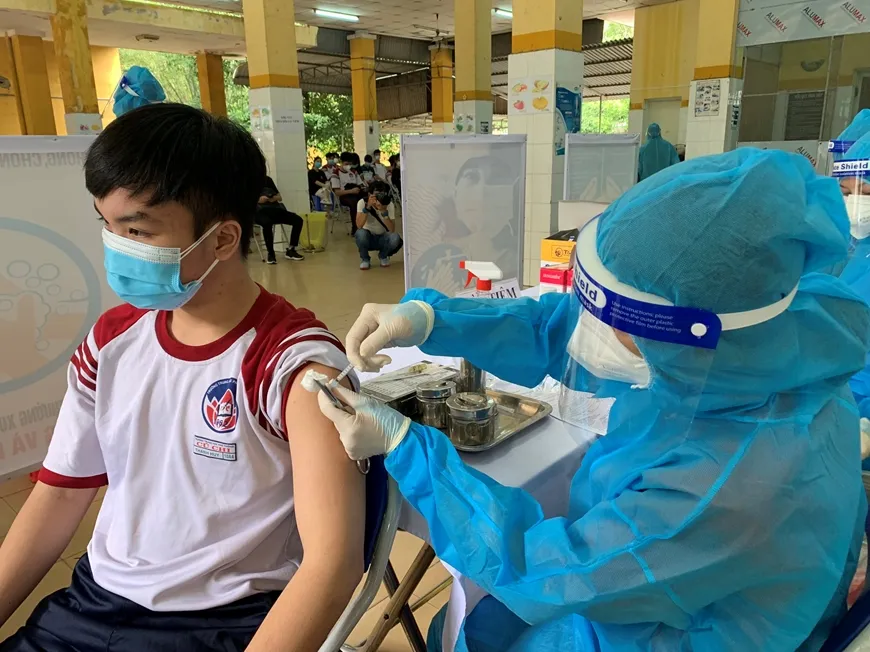 Nhân viên y tế tiêm vắc xin phòng Covid-19 cho học sinh. 