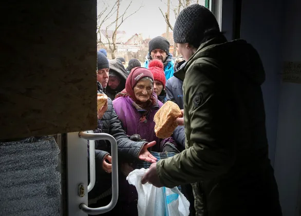 Người dân ở thành phố Mariupol, Ukraine nhận bánh mì ngày 4-4 trong một đợt phân phát viện trợ nhân đạo trong bối cảnh giao tranh đang diễn ra ở đây - Ảnh: REUTERS