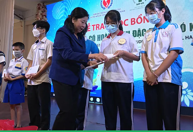 Bà Nguyễn Thị Bích Ngọc, Chủ tịch Hội Bảo trợ người khuyết tật và trẻ mồ côi thành phố trao học bổng và quà cho các em học sinh mồ côi do đại dịch Covid-19. 
