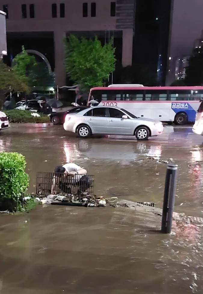 Người hùng trong trận mưa kinh hoàng tại Hàn Quốc, dùng tay không bốc hết rác bẩn che miệng cống 8