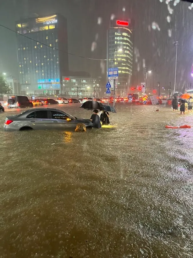 Người hùng trong trận mưa kinh hoàng tại Hàn Quốc, dùng tay không bốc hết rác bẩn che miệng cống 1
