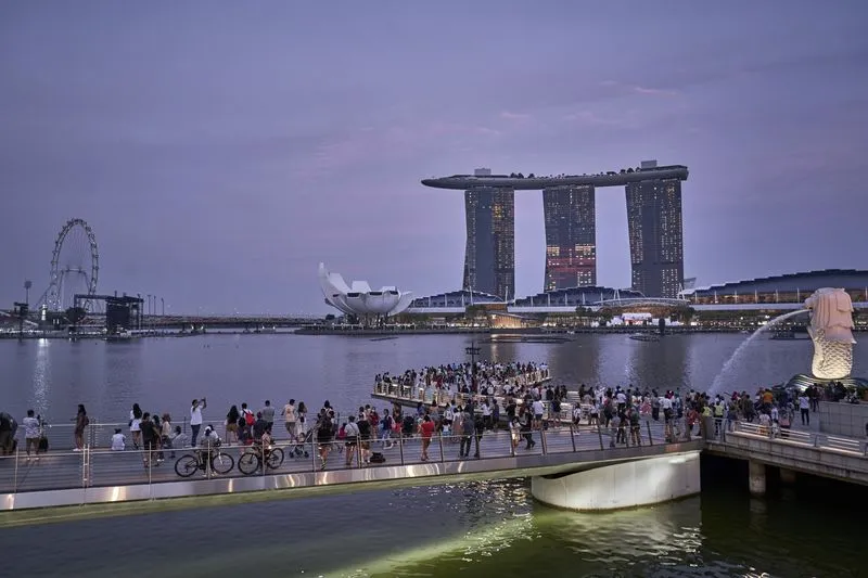 Khách tham quan tượng Merlion và khách sạn Marina Bay Sands ở Singapore. Ảnh: Bloomberg