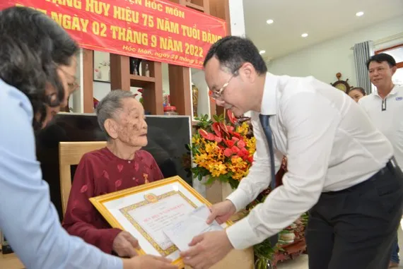 Phó Bí thư Thành uỷ TPHCM Nguyễn Văn Hiếu trao Huy hiệu 75 năm tuổi Đảng cho đồng chí Trịnh Thị Tẻo. Ảnh: 