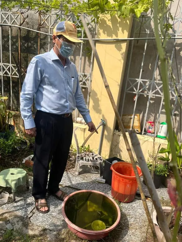 Ông Nguyễn Hữu Hưng - phó giám đốc Sở Y tế TP.HCM - phát hiện nhiều lăng quăng trong các vật phế thải tại một trường học ở quận 8 - Ảnh: T.DƯƠNG