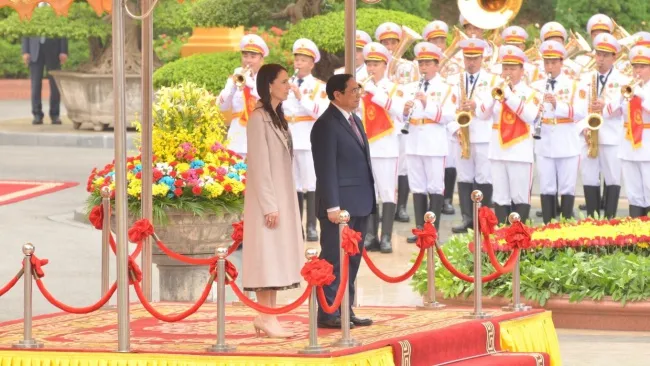 Thủ tướng Phạm Minh Chính và Thủ tướng New Zealand Jacinda Ardern thực hiện nghi lễ chào cờ 