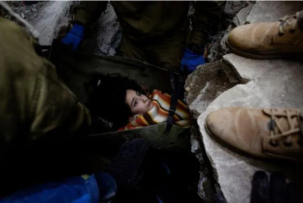 Lực lượng cứu hộ đang đưa một bé gái 14 tuổi ra khỏi đống đổ nát  