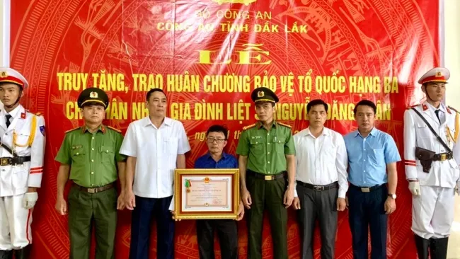 Lãnh đạo UBND tỉnh Đắk Lắk trao Huân chương Bảo vệ Tổ quốc hạng Ba cho thân nhân gia đình liệt sĩ, đại uý Nguyễn Đăng Nhân - Ảnh: PLO