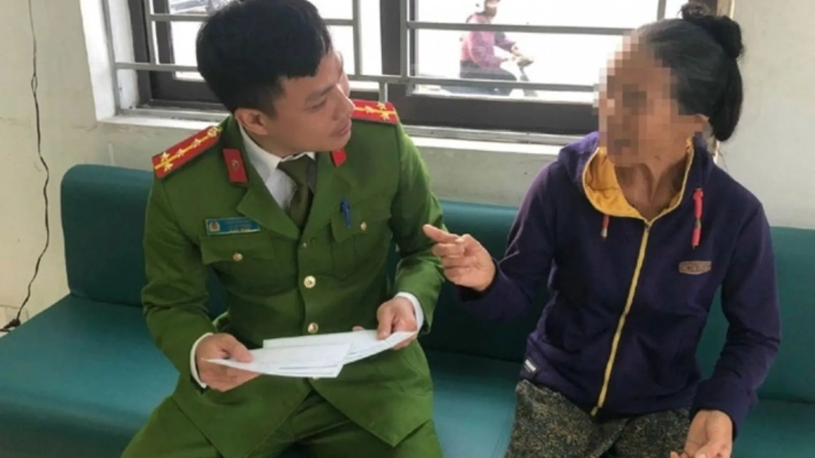 Bà C. được cán bộ Công an giải thích về những vụ lừa đảo - Ảnh: TTO