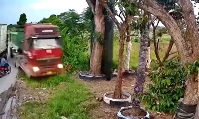 Xe container tránh xe tải trên quốc lộ lao vào vườn nhà ven đường