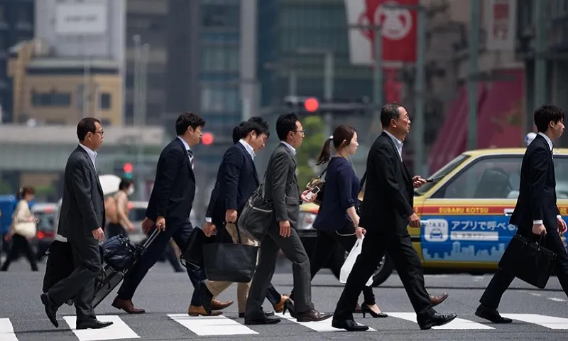 Nhân viên công sở đi bộ đến nơi làm việc ở Tokyo Japan Times.