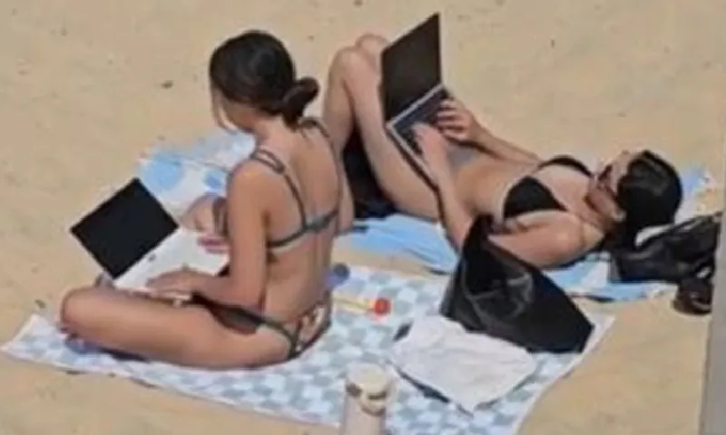 Bùng nổ tranh cãi về hình ảnh 2 cô gái mặc bikini làm việc bên laptop ngoài bãi biển