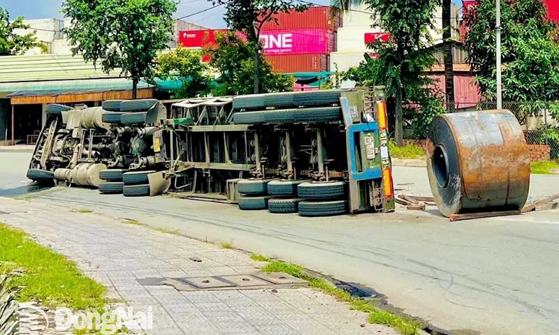 Xe tải chở thép lật ngang, cuộn thép rơi xuống đường, tài xế bị thương