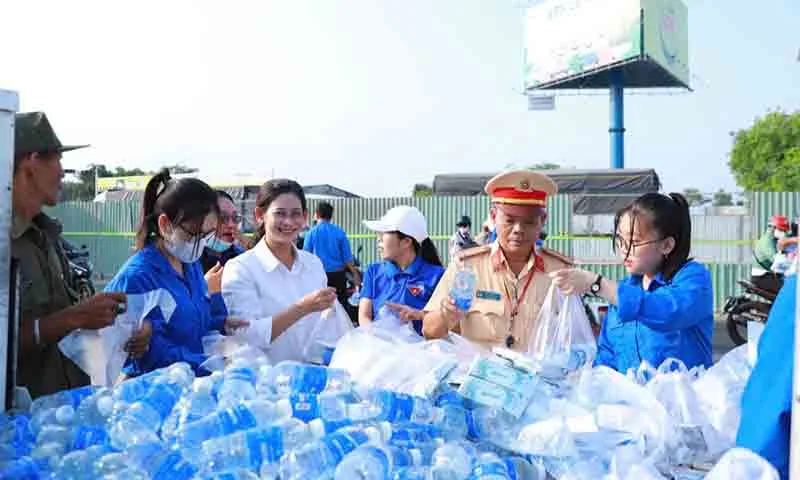 Điểm phát nước suối, khăn lạnh, bánh mì tại ngã ba đường dẫn cầu Vàm Cống.