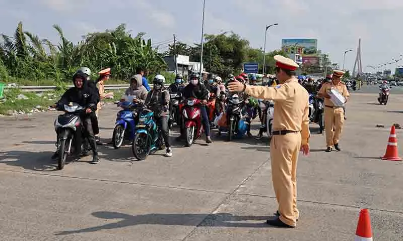 Cảnh sát giao thông phát nước suối, bánh mì cho người dân đi xe máy về quê ăn Tết