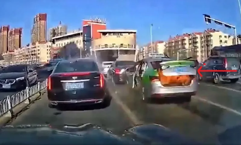 Cốp xe taxi màu trắng bên phải khi dừng đèn đỏ đã nổ tung