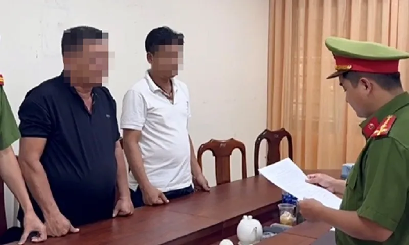 Lực lượng công an công bố quyết định khởi tố bị can đối với 2 đối tượng - Ảnh CACC