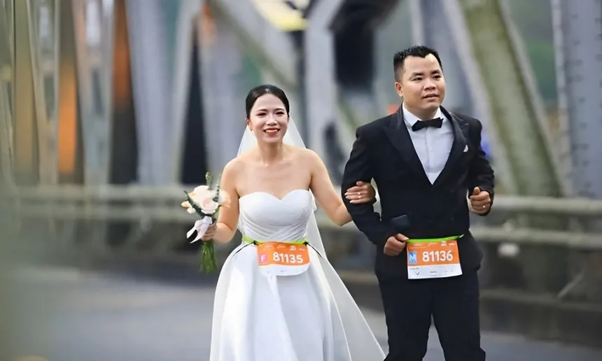 Cô dâu và chú rể mặc đồ cưới cùng nhau hoàn thành giải bán marathon ở Huế