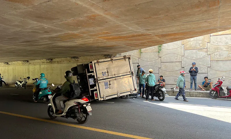 Xe tải va vào thành hầm chui rồi lật nhào, đè 2 xe máy